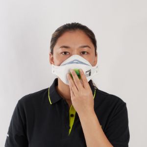 With both straps held on the top panel, place opened respirator in one hand against your face, with the nosepiece across the bridge  of your nose.